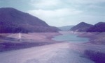 Watauga Lake drained for maintenance on dam, 1983.  View of Dam from Rat Branch Launch Ramp..