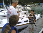 Taylor, Bill Murdoch, and Clay fishing on dock after race